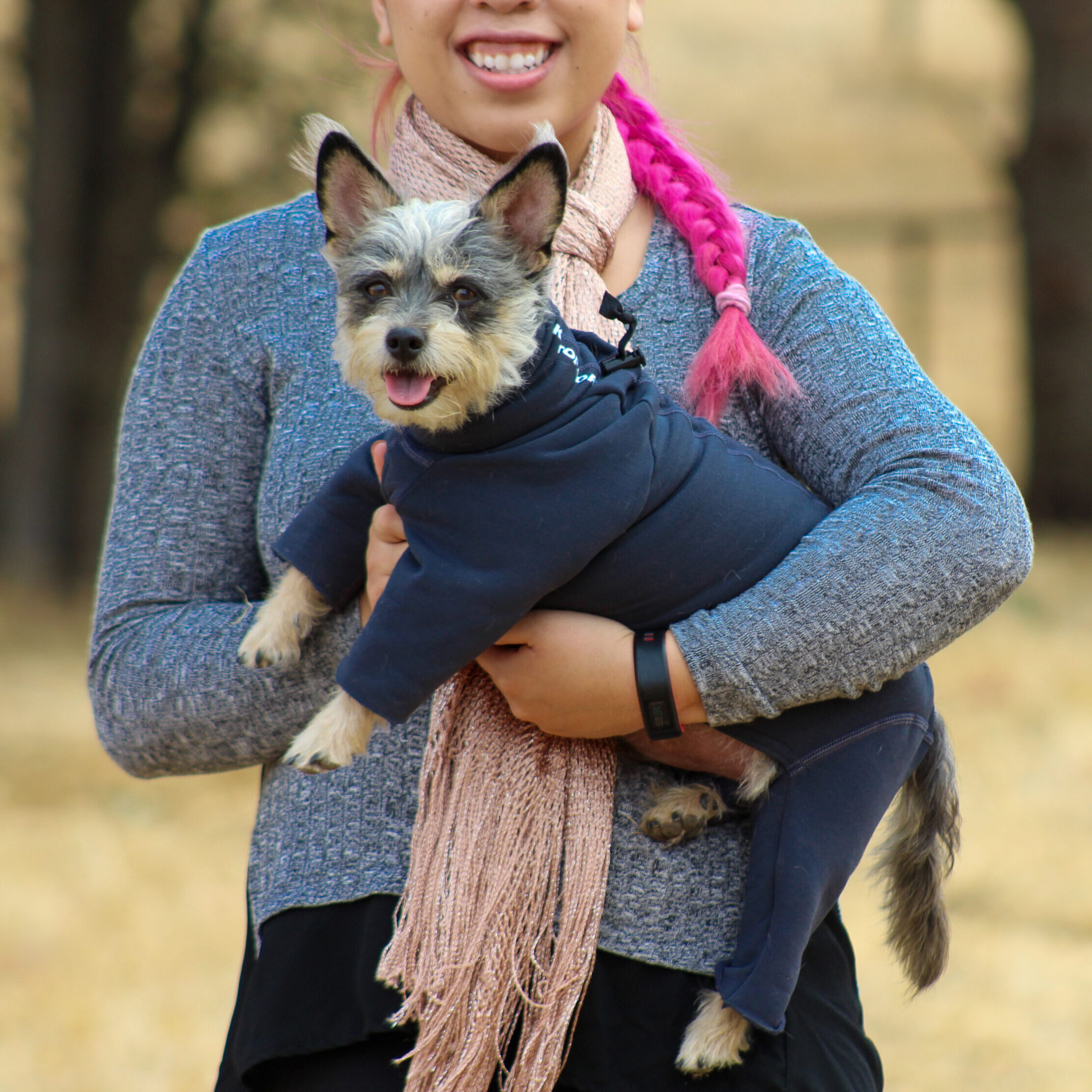 Woman Holding Small Dog in Bodysuit